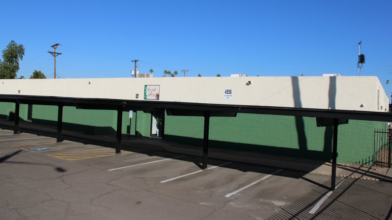 The Mana Health and Wellness building at 4550 N Black Canyon Hwy, Phoenix, with its green wall and covered parking