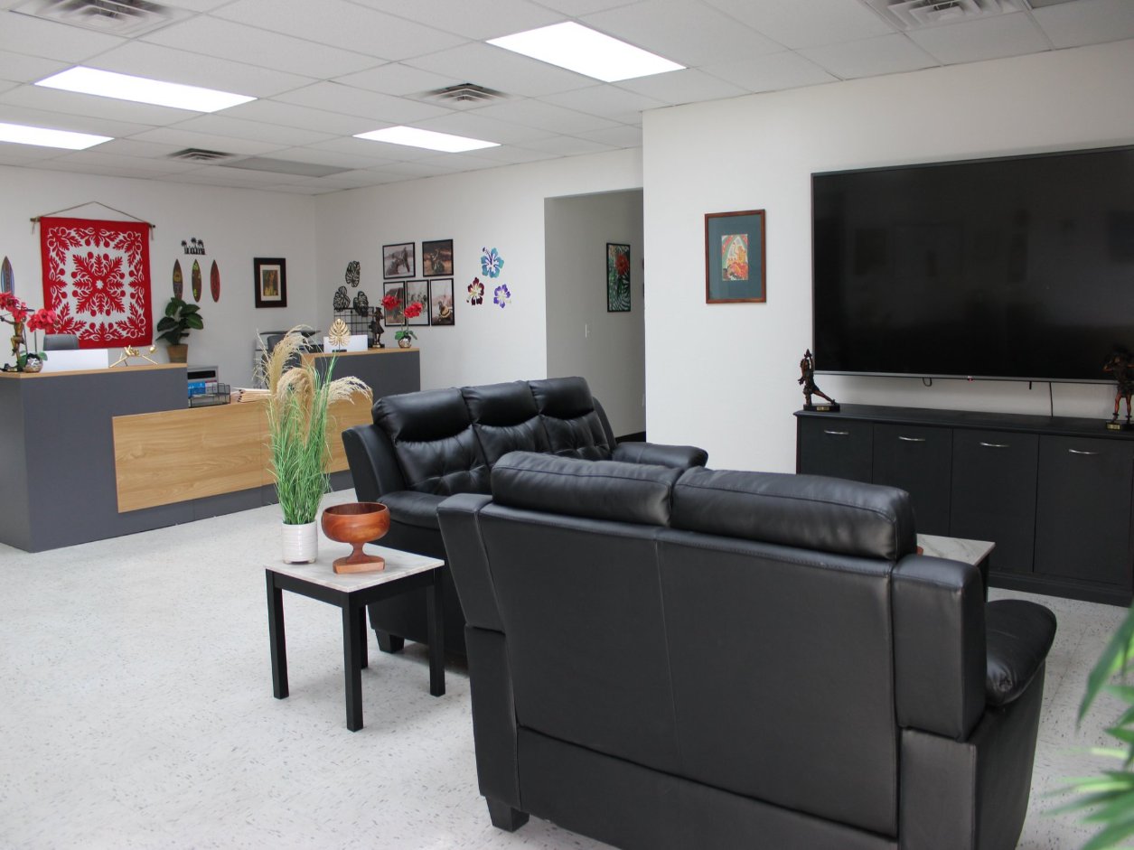The Mana Health and Wellness lobby, with a red Hawaiian quilt on the wall, seating and the reception desk